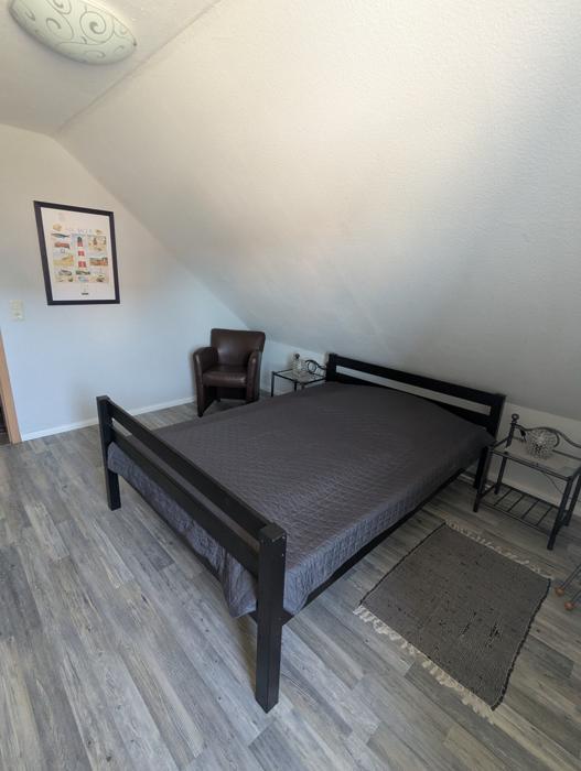 Doppelbett mit Nachttischen unter der Dachschräge